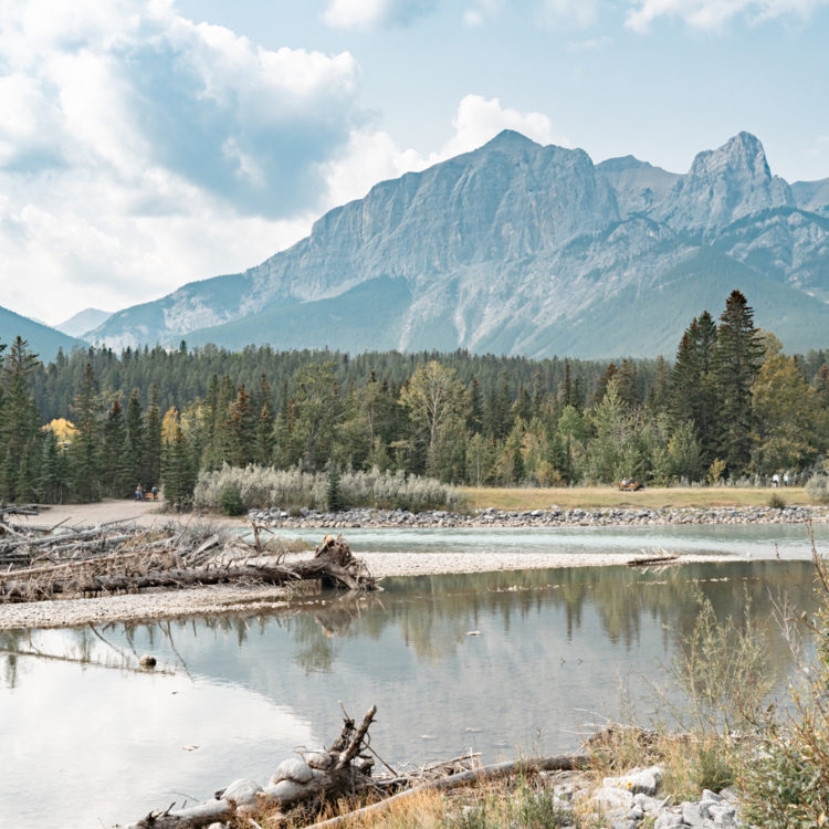 カナダ・キャンモアのボウ川と青空に映えるロッキー山脈の縦位置風景
