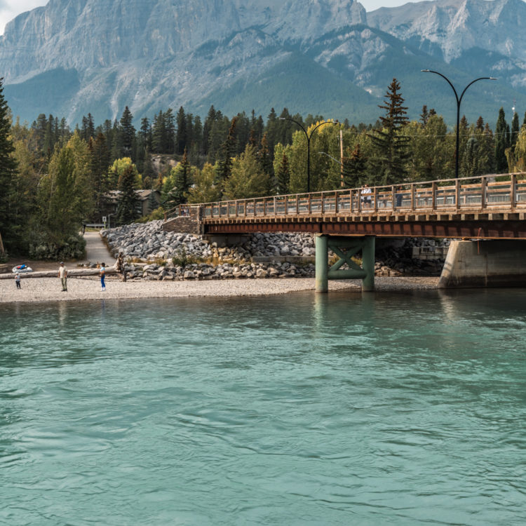 カナダ・キャンモアの雄大なロッキー山脈とエメラルドグリーンの川に架かるMr. Bridge